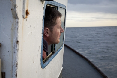 Richard Scott on board of his lobster boat 'Fiona S' looks by the cabin window while on his way to haul his creels in the Firth of Forth in Scotland in Ocotber 2011.