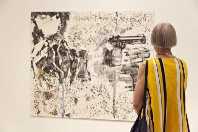 Woman in striped dress looks at one of Steve Pratt painting during the private view of his exhibition in the Aine Art Museum in Tornio, Finland, in June 2011.