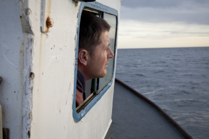 Richard Scott on board of his lobster boat 'Fiona S' looks by his cabin window.